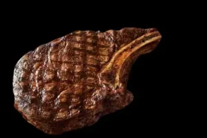 "Outback Steakhouse Ribeye steak marbled and juicy, seasoned and grilled over an open flame, served with classic sides"

